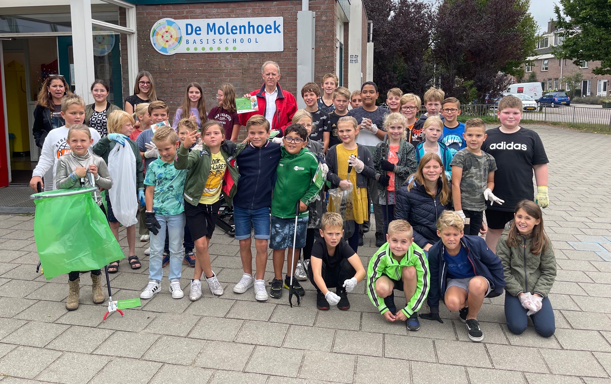 Wethouder Brouwer (rode jas) deelt Zwerfafvalbingokaarten uit. Molenhoek-Leerlingen: Wethouder Brouwer (rode jas) deelt Zwerfafvalbingokaarten uit. Molenhoek-Leerlingen: