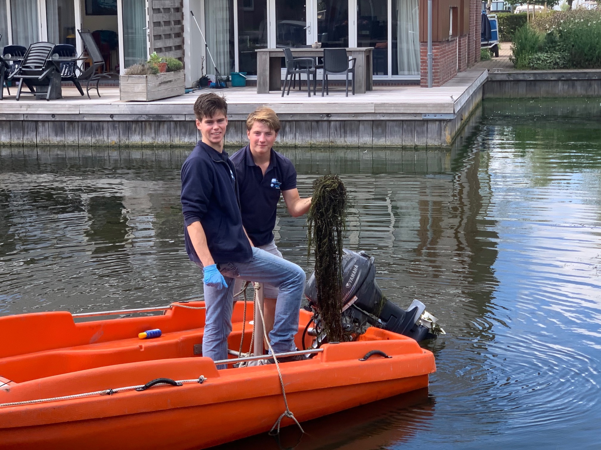 David Heesterbeek en Philip Brinkman (r.) doen een poging om de waterplanten uit de Jachthaven te harken (foto: Anita Webbe) David Heesterbeek en Philip Brinkman (r.) doen een poging om de waterplanten uit de Jachthaven te harken (foto: Anita Webbe)